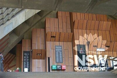 Interior of foyer area showing Utzon colour-coded signage, also detailing wood panelling and concrete-work