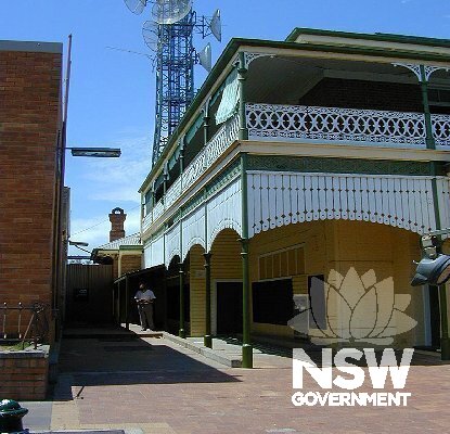 View looking northeast of the front facade corner and western facade.  Note the detailing of the timber valance, cast iron lacework work and posts.  Also note the proximity of the intrusive Telstra exchange building to the left of photo.