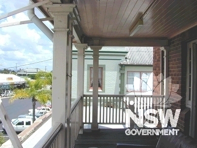 View looking west of the first-floor residential balcony, showing timber post and balustrade detail.