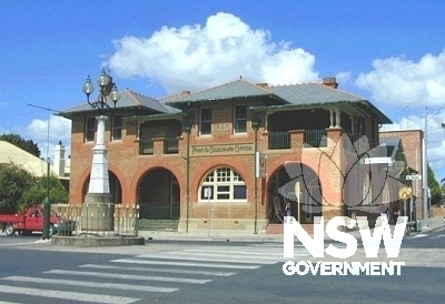 View looking east of the Grey Street facade of Glen Innes Post Office, showing the Boer War Memorial in the centre of the street and pedestrian crossing.