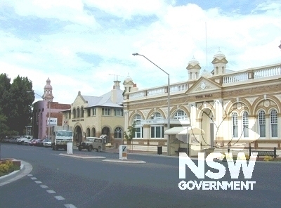 Street view looking south showing Inverell Post Office between an Art Deco style building in the background and the stylised Free Classical Town Hall in the foreground.