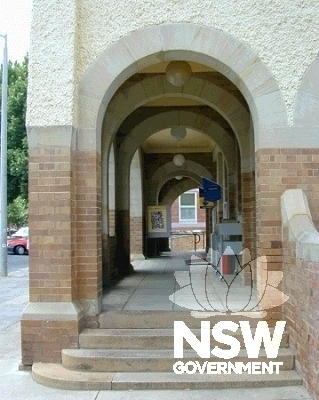 View looking southeast of the side entry to the front verandah, showing stone voussoirs, roughcast render and face brickwork.  Note the later pendant light fittings to the soffit.