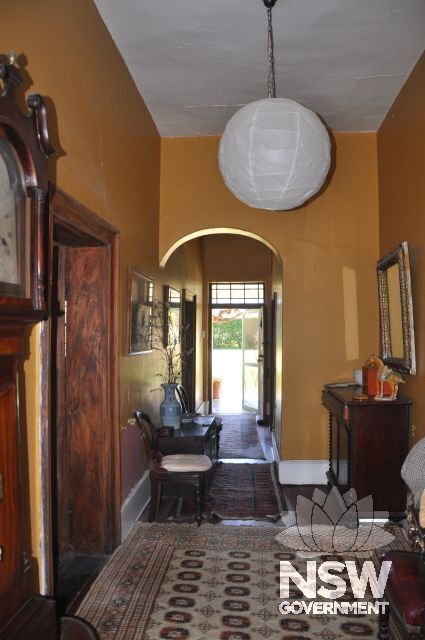 Interior photo of the Grannge farmhouse's hallway, view from south towards north entrance doorway with rectangular lighting details.
