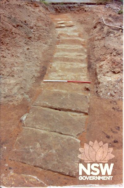 Sandstone capped drain thought to be associated with the circa 1790 military barracks. The drain was uncovered during archaeological testing by Casey and Lowe Pty Ltd in 2003.
