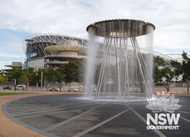 Cauldron, now a fountain in the Overflow, Sydney Olympic Park, next to the ANZ Stadium where it was positioned 46 metres above the ground, alight, during the Sydney Olympic Games in September 2000