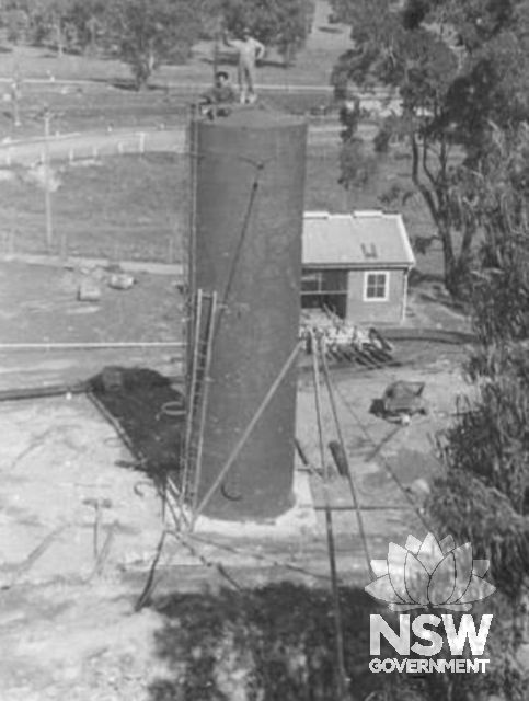 Two unidentified men standing on top of a fuel storage tank at Cootamundra, probably as it is being installed c1941.  Courtesy National Library of Australia via Rappoport, 2011