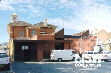Rear elevation of Hay Post Office, showing the single-story brick additions and carparking.