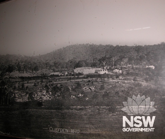 Early photograph of Cliefden (1870) shows graveyard and the scale of the barn and woolshed building. Photograph of photo hanging in the house.