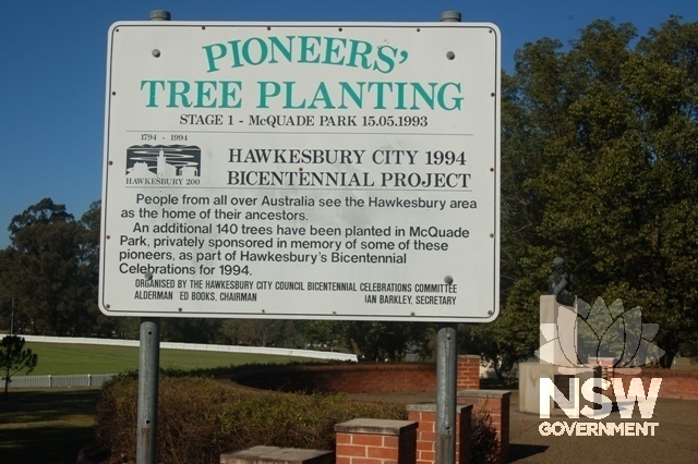 McQuade Park - Signage for 1994 tree planting with Macquarie statue and commemorative trees beyond.