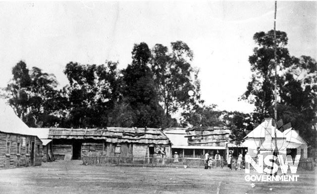 Circa 1897 (the teacher’s cottage and slab kitchen on the right burned down in 1897). Taken from around the church area, with possible original Gribble cottage (later manager’s cottage) on the left. Provides good detail of Aboriginal housing and fencing.