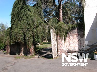 1 Fleet Street, Parramatta. Wooden gate and overgrown brick wall, at southern area of the compound.