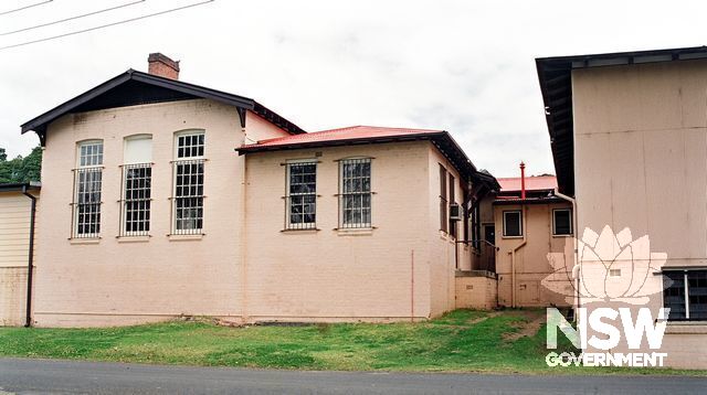 The Main Store at the Hospital. Gable roofed east section (left) is the back of a 1916 (?) brick building. Hip-roof addition (centre) is c1930s. Wall on the right is part of a c1920s section, with half- basement & ripple-iron cladding. (Doring Neg.405.36)