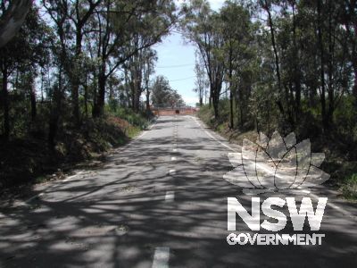 The stretch of the now disused Old Windsor Road at the approximate location of the culvert.  Meurants Lane to the north can be seen in the background. The new road alignment is to the east at the right of the photo.