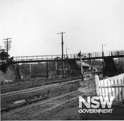 Fassifern Railway Station - View south from Newcastle end of platform. Toronto Line branch platform at left, with the main line platforms and footbridge in the centre. Tracks in foreground lead to a short goods siding behind down platform.  c.1951