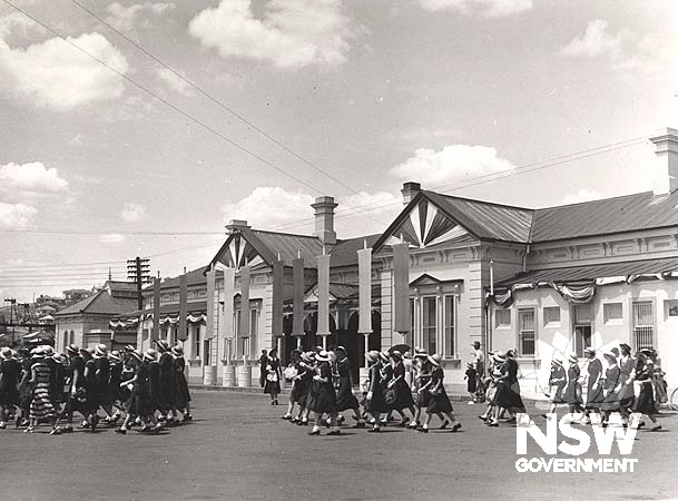 School children preparing for the arrival of Queen Elizabeth 11 at Wagga Wagga Railway Precinct- view of approach side, 1954.