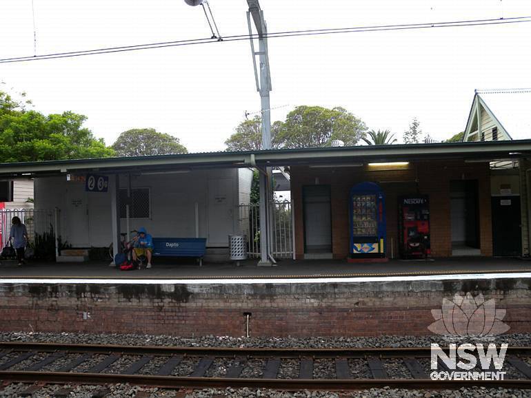 Dapto Railway Station - Platform 2 (east  platform) - west elevation - modern buildings to north of  1887 main platform building - 1970 toilet block to right