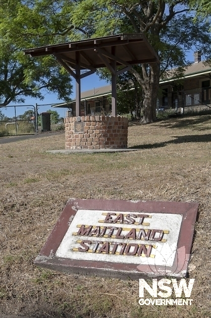 Concrete station name set in lawn with raised letters - Wishing Well in background
