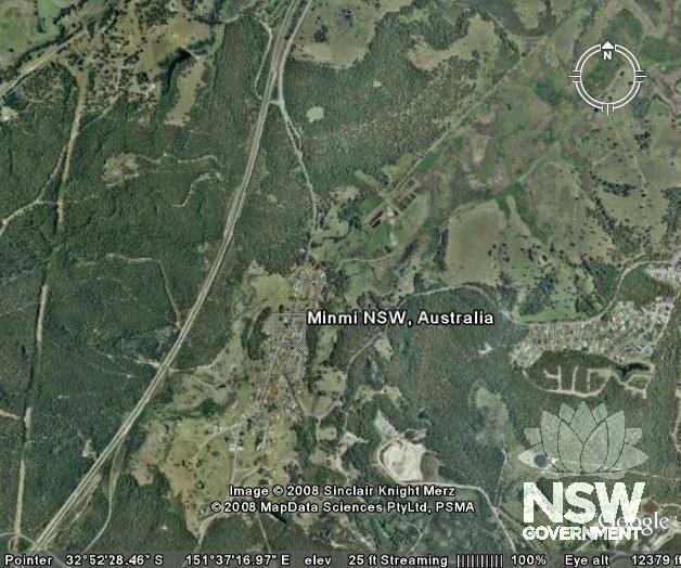 Aerial view from Google Earth. Railway corridor is visible to north-east of Minmi township travelling diagonally towards Hexham (just above compass diagram). [Source: Google Earth - Minmi]